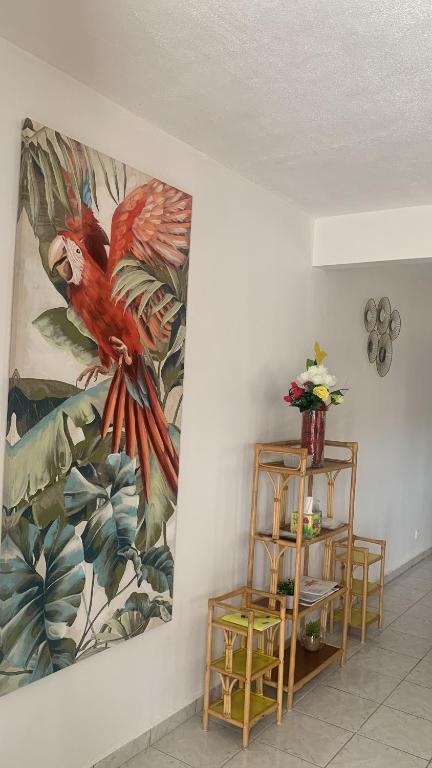 una pared con una pintura de un loro en ella en villa des aigles en Anse-Bertrand