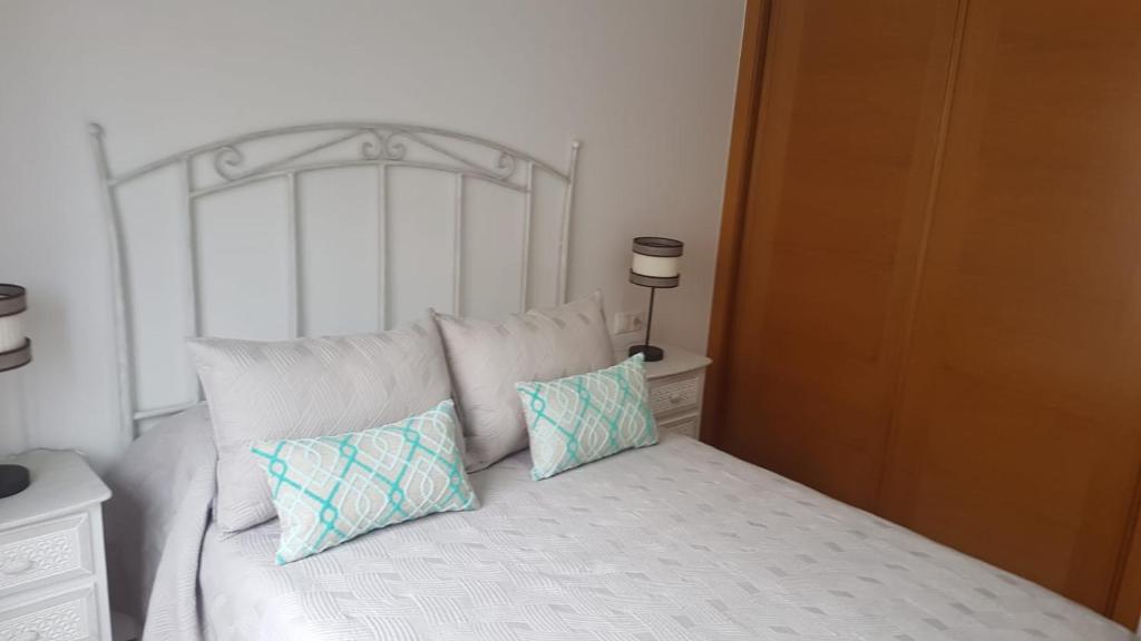 a white bed with two pillows on top of it at APARTAMENTO A CHILENA in Cambados