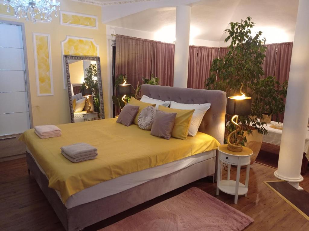 sypialnia z dużym łóżkiem z żółtą pościelą i poduszkami w obiekcie Villa M.COCO w Puli