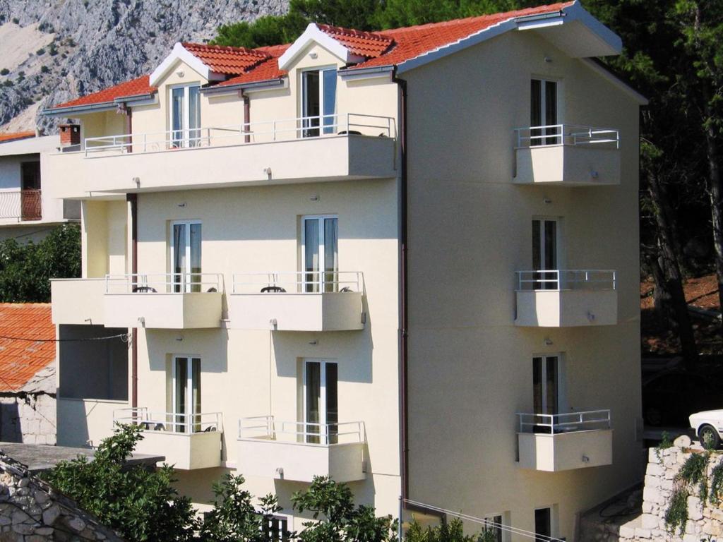 un edificio blanco con balcones en un lateral en Apartments Danica Drašnice en Drasnice