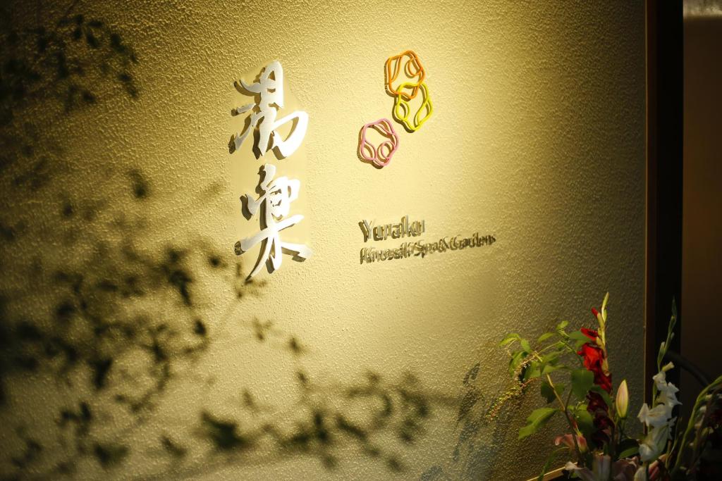 a wall with japanese writing on it at Yuraku Kinosaki Spa & Gardens in Toyooka