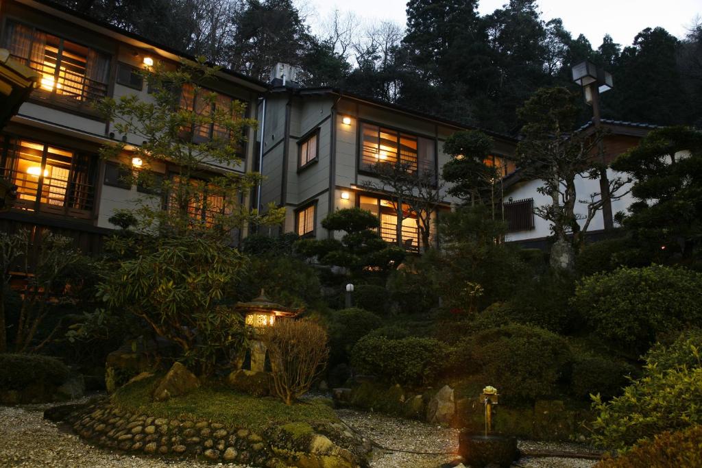 a house with a garden in front of it at night at Yuraku Kinosaki Spa & Gardens in Toyooka