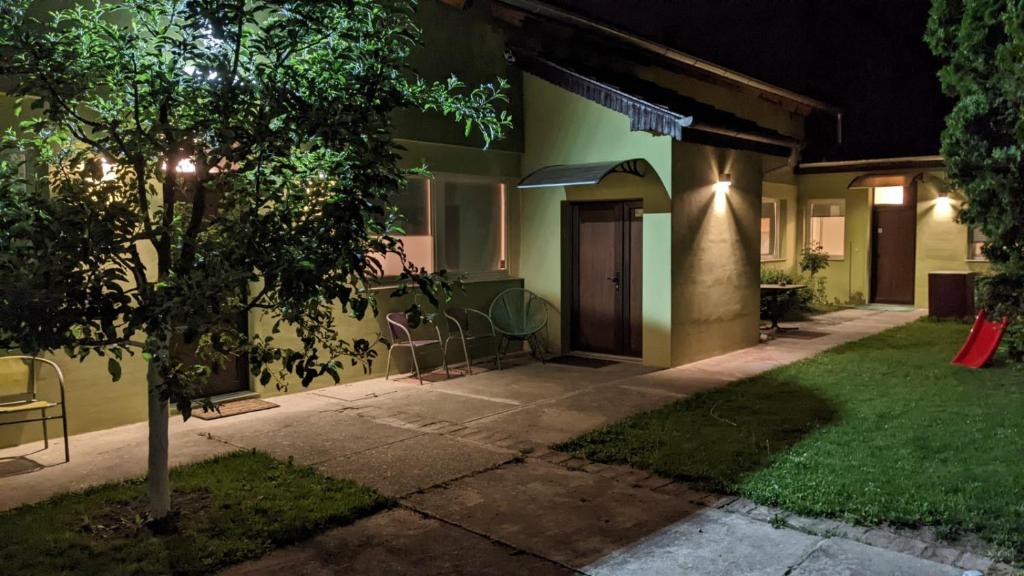 a house with a tree in the yard at night at Green Garden Group Accommodation in Osijek