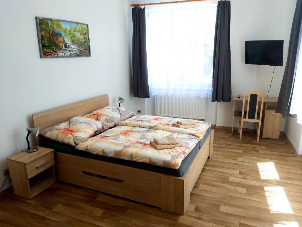 a bedroom with a bed with a wooden floor at Apartmány Na Valše in Sušice