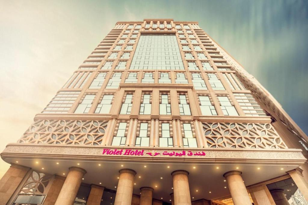 a tall building with a sign on it at Violet Al Azizia Hotel in Mecca