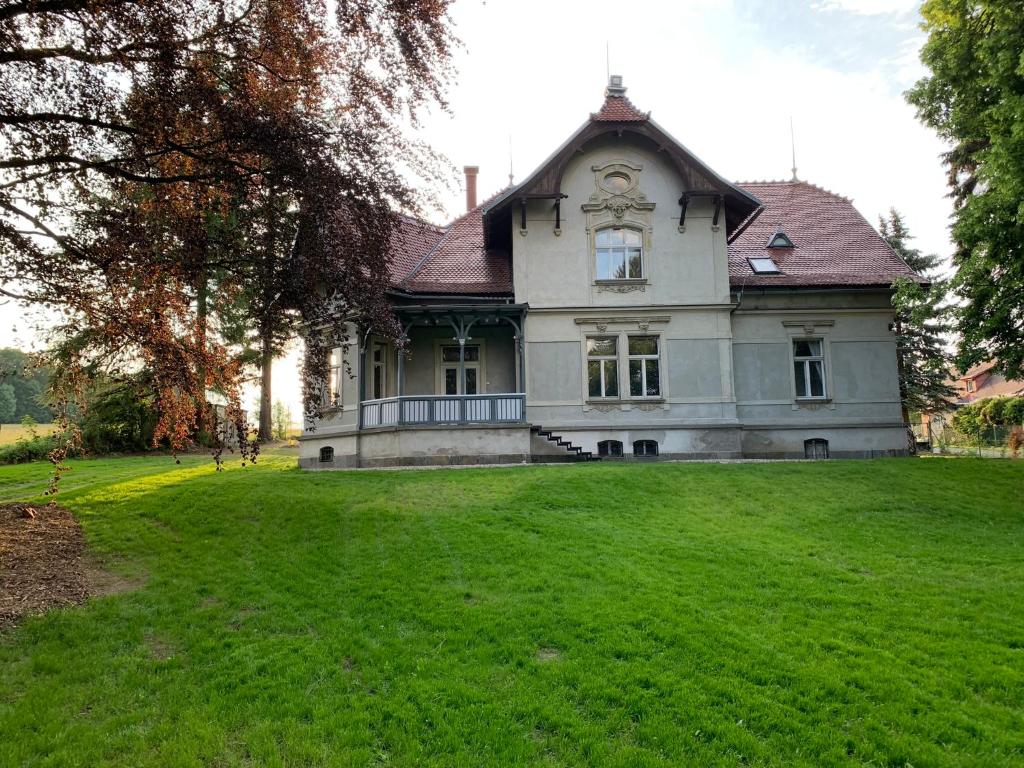 une maison ancienne avec une grande pelouse dans l'établissement Vila Bohemia Saxon Switzerland, à Šluknov