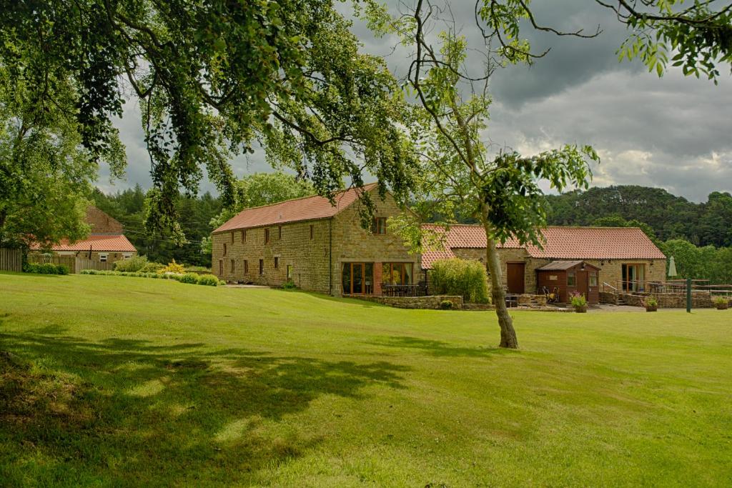 una casa de ladrillo con un árbol en un campo en Experience the Peace & Quiet in the North York Moors at Rawcliffe House Farm, en Pickering