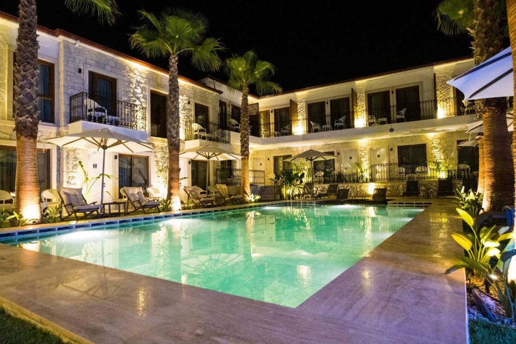 a swimming pool in front of a hotel at night at İcarus Alaçatı in Çeşme
