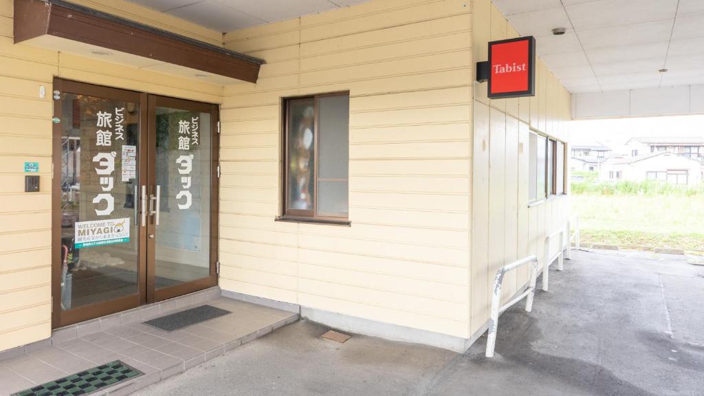 un bâtiment avec un panneau sur son côté dans l'établissement Tabist Business Ryokan Duck Ishinomaki Hebita, à Ishinomaki