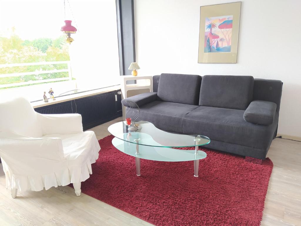 ein Wohnzimmer mit einem Sofa und einem Couchtisch aus Glas in der Unterkunft Ferienpark Sierksdorf App 705 - Strandlage in Sierksdorf