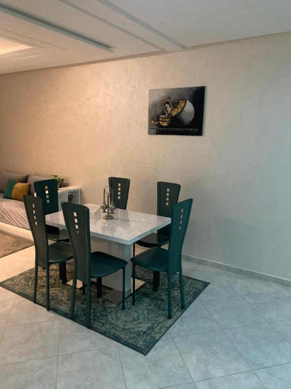 a dining room with a table and chairs at Appartement avec piscine et proch de plage in Kenitra