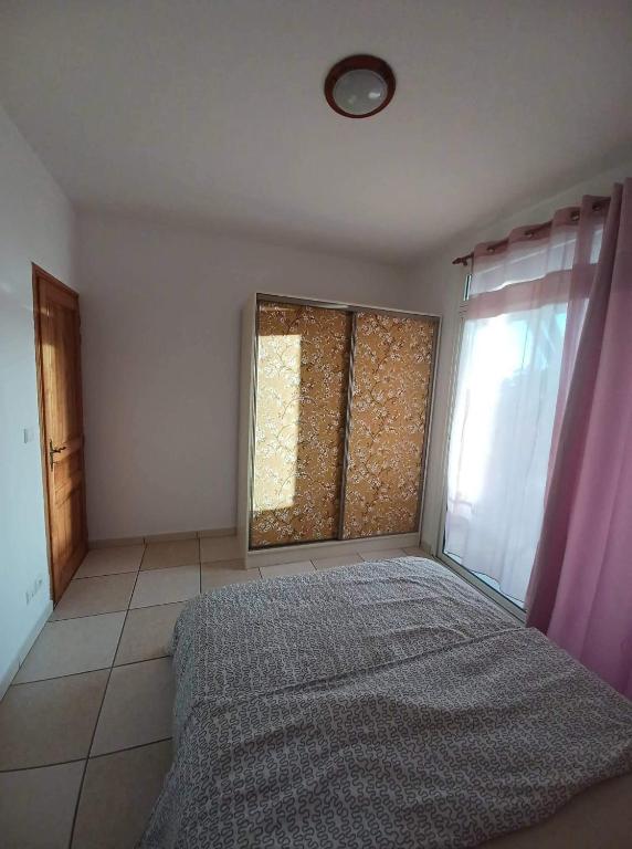 Postel nebo postele na pokoji v ubytování Les Chandels Appartement avec terrasse vue mer Manapany les bains