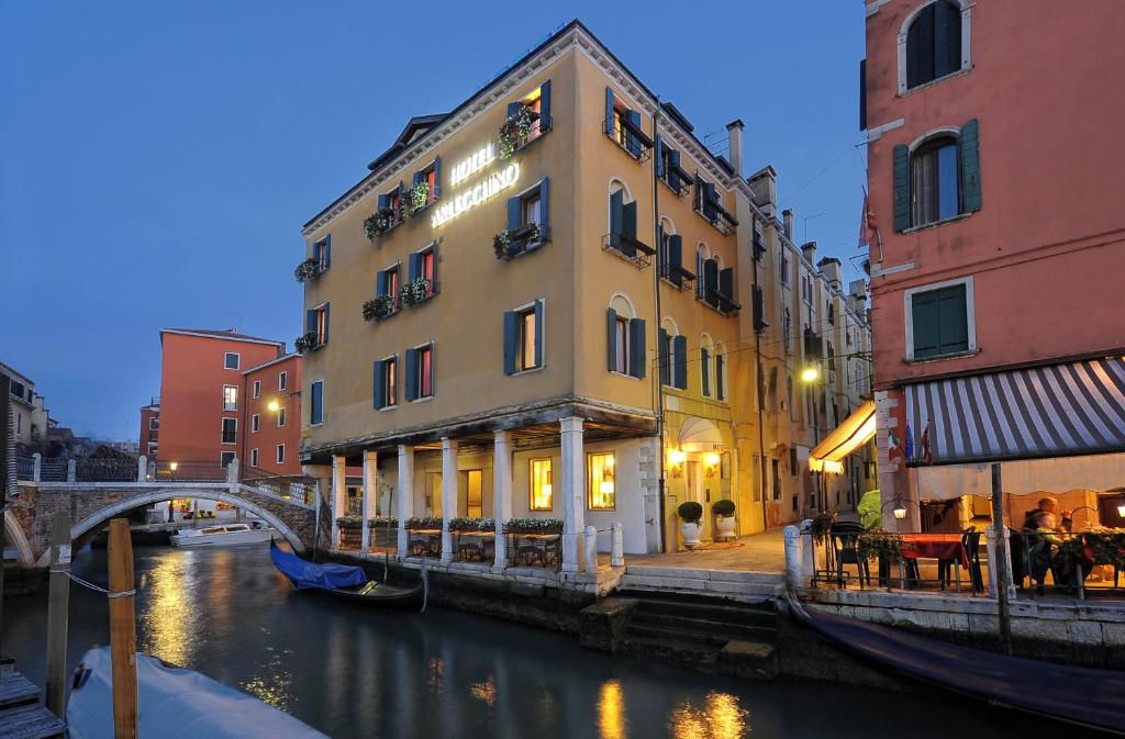 a building next to a canal in a city at Hotel Arlecchino in Venice