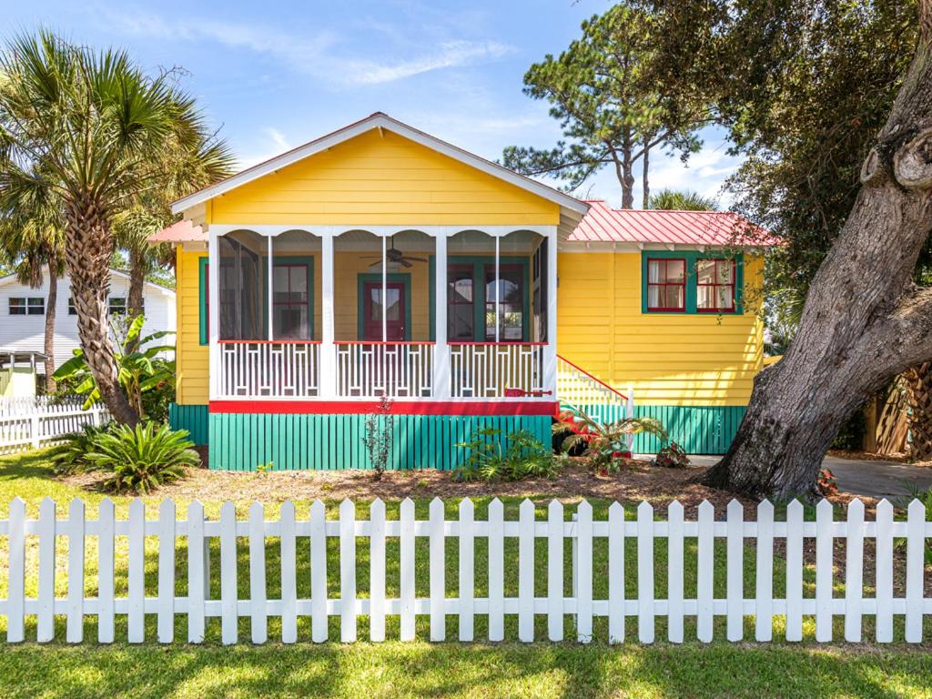 een geel huis met een wit hek ervoor bij Coastal Soul Cottage in Tybee Island