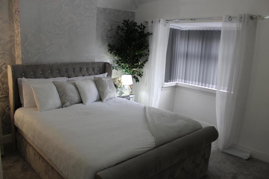 a bedroom with a large bed with a window at Luxury 3 Bedroom House in Birmingham