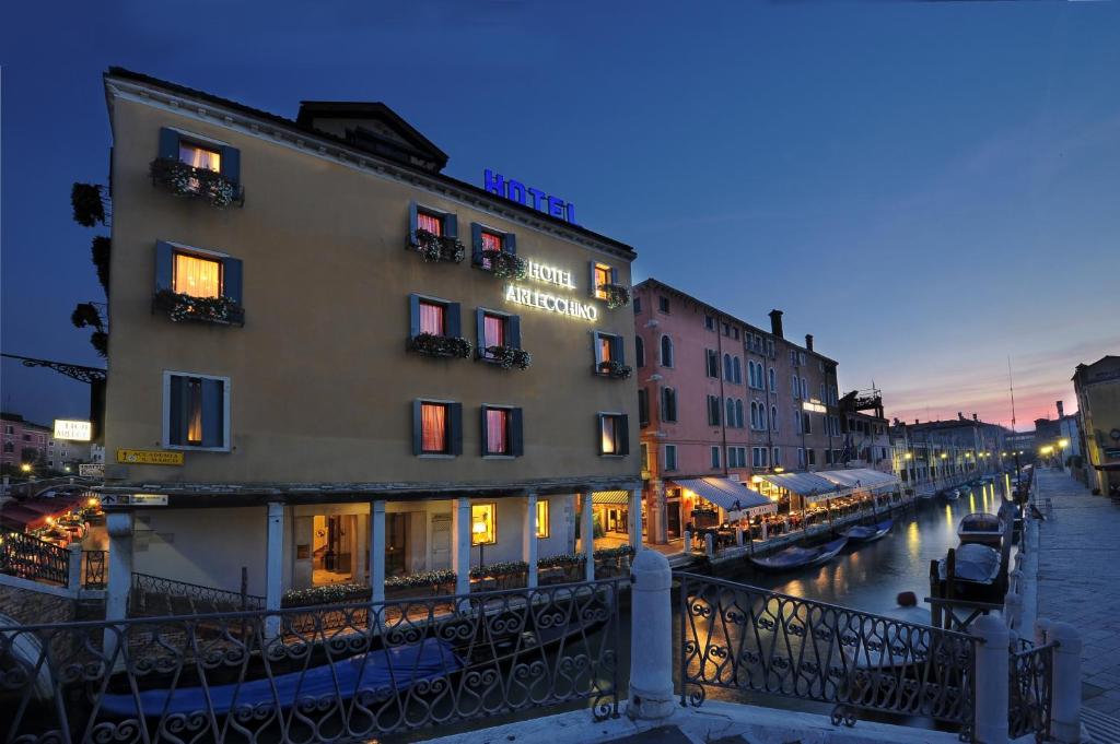 a building next to a canal at night at Hotel Arlecchino in Venice