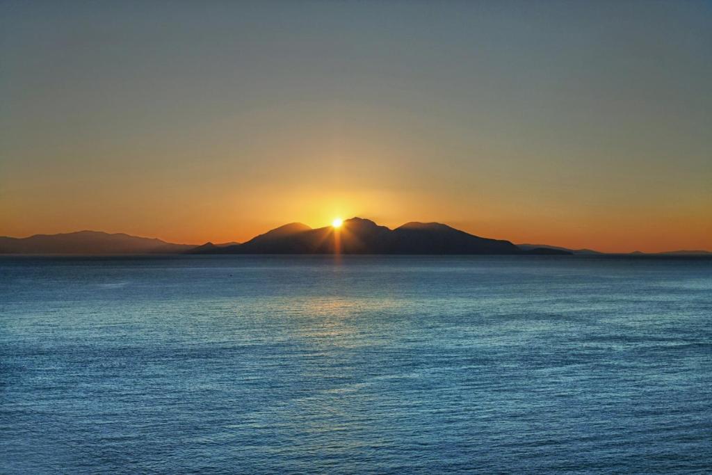 a sunset view of the ocean from a boat at Κastro Ηotel in Agios Kirykos