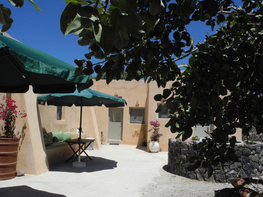 a patio with a table and an umbrella at Magma & Tefra in Éxo Goniá