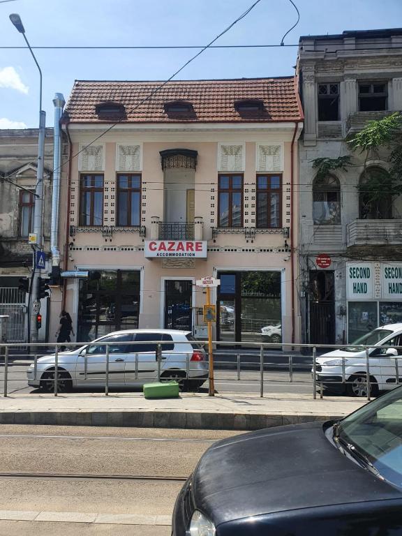 un edificio en una calle de la ciudad con coches aparcados delante en Cazare - Accommodation, en Bucarest