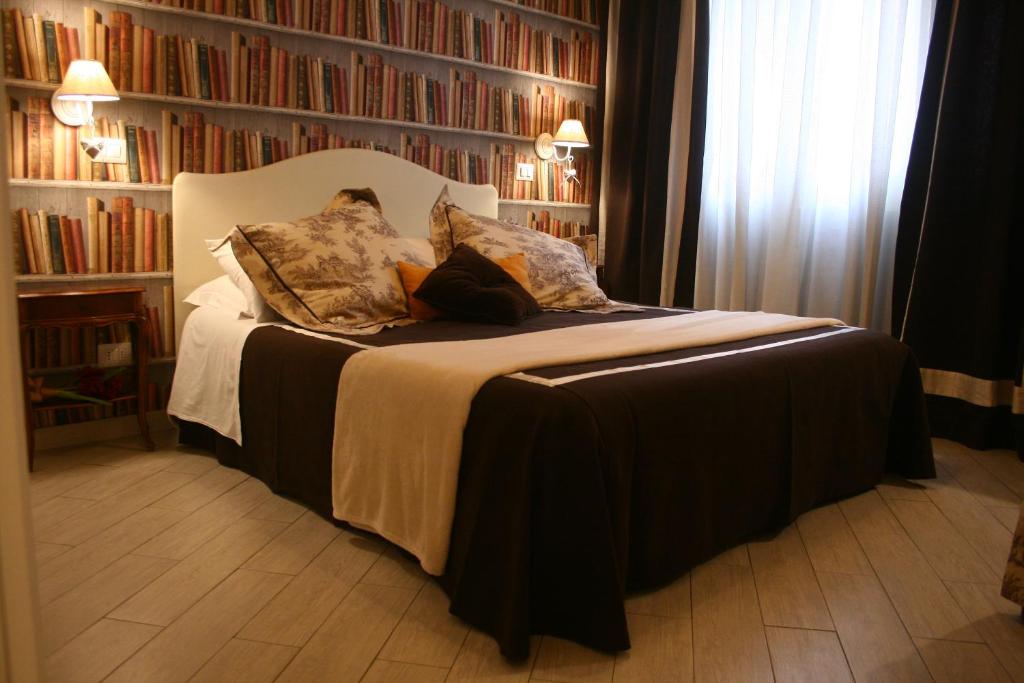 ローマにあるLe Stanze dei Cardinaliのベッドルーム1室(大型ベッド1台、本棚付)