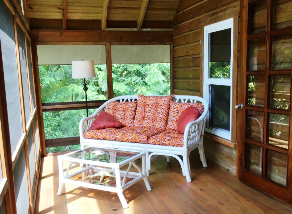 - un canapé blanc installé sur une terrasse couverte avec une table dans l'établissement Phoenix House, à Sandy Bay