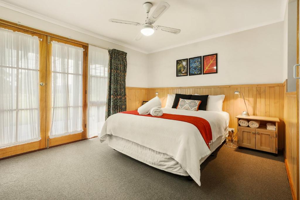 a bedroom with a large bed and windows at Summerfield Winery and Accommodation in Moonambel