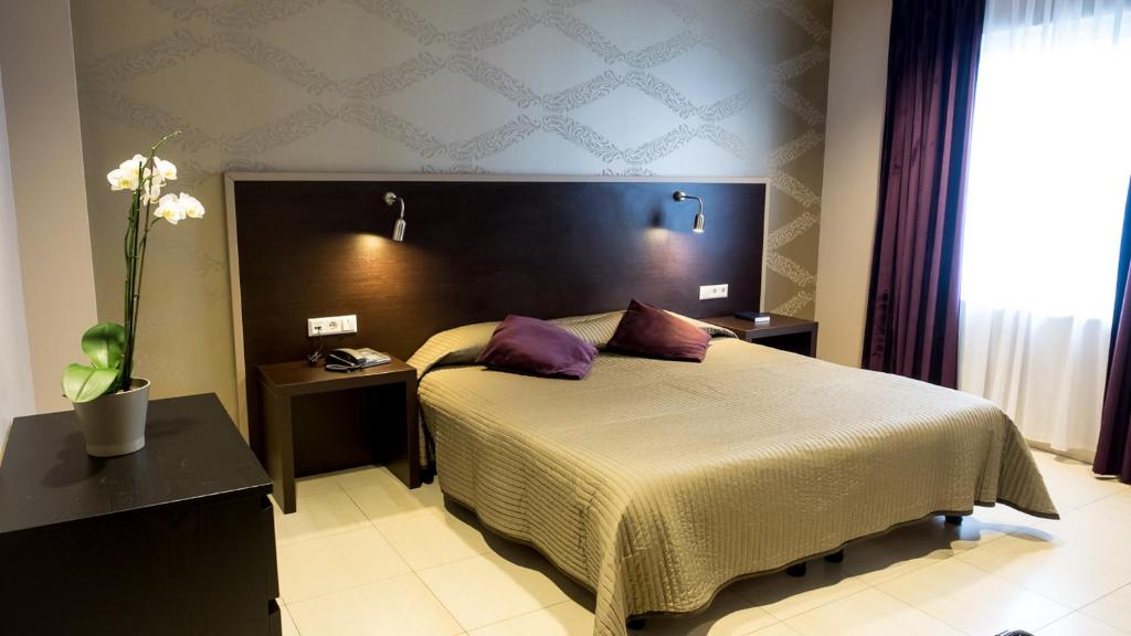 a bedroom with a large bed with purple pillows at Hotel Pax in Luxembourg