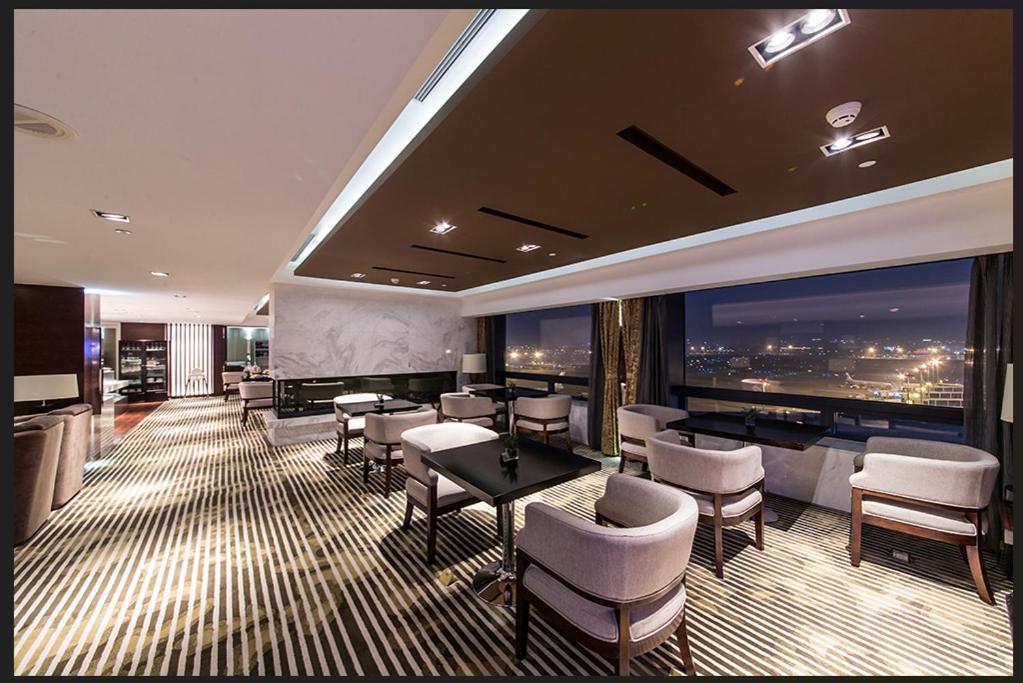 a restaurant with tables and chairs and a view of the city at Shanghai Hongqiao Airport Hotel - Air China in Shanghai