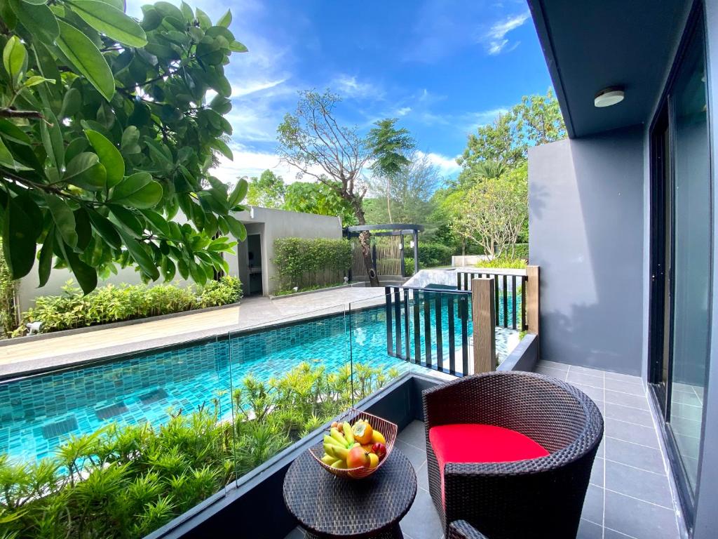 a balcony with a table and chairs and a swimming pool at The aristo-access pool room Surin beach in Phuket