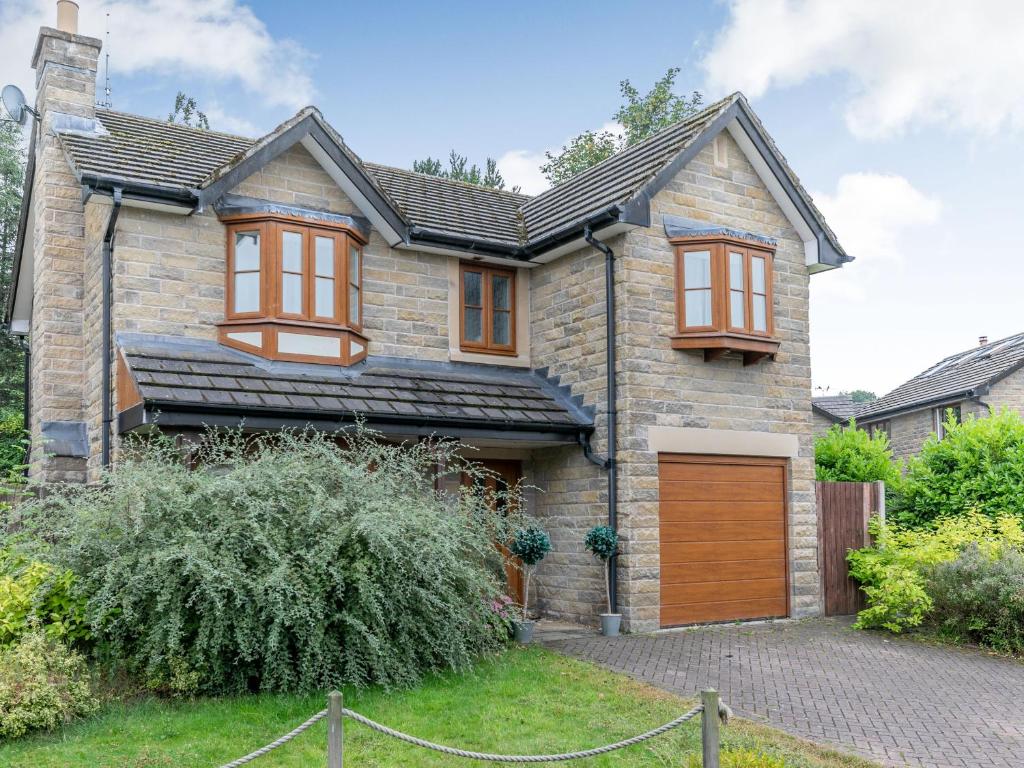 a brick house with brown windows and a garage at 2 Carr Farm Close in Glossop