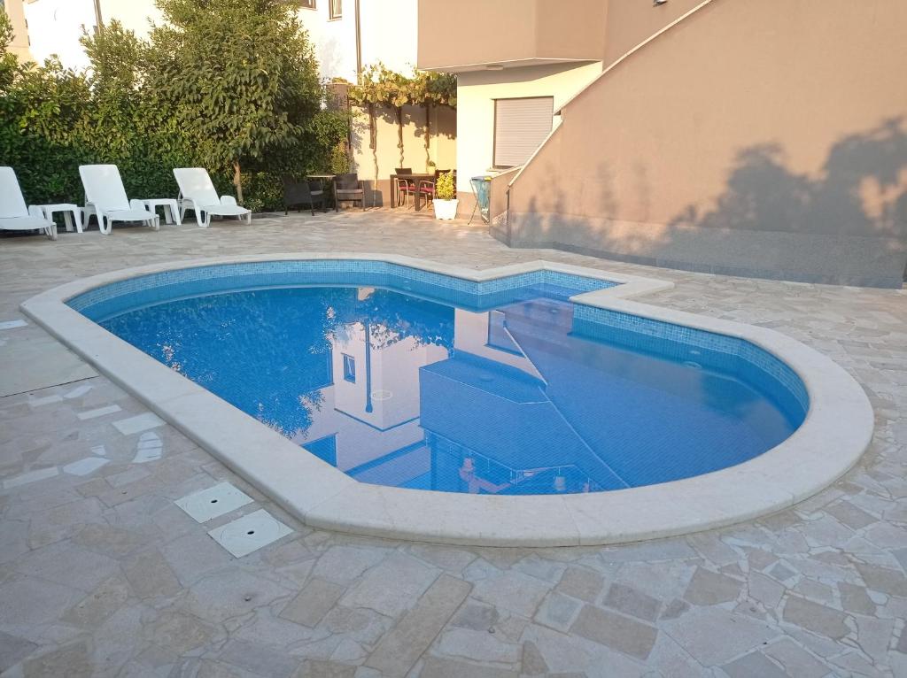 - une piscine dans une terrasse entourée de chaises dans l'établissement Studio apartment with pool, à Pula
