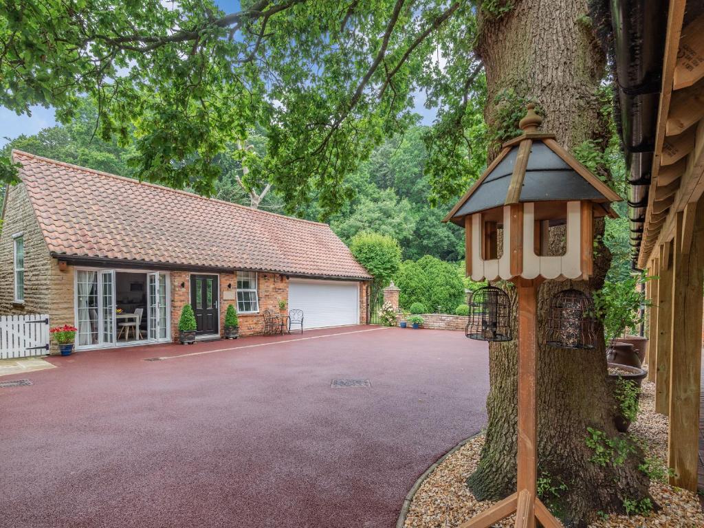 una casa de pájaros en un árbol delante de una casa en Silvadale Cottage en Louth