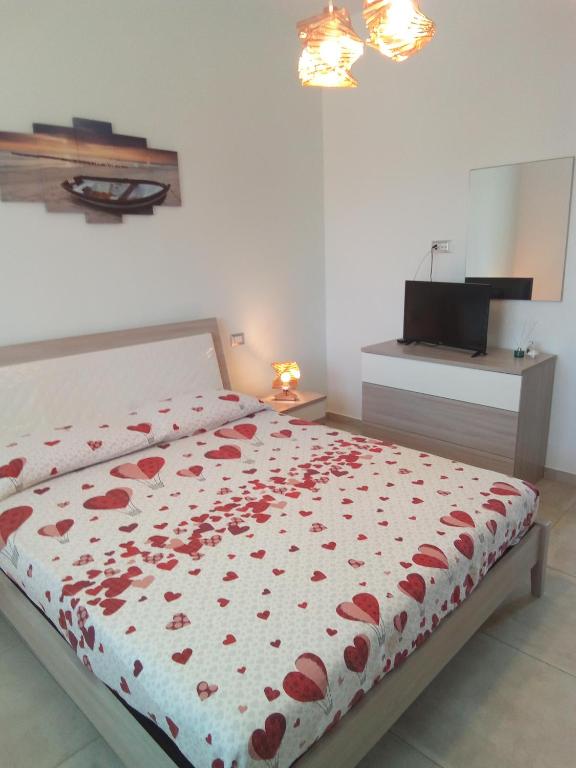 a bedroom with a bed with red flowers on it at Villa Anna Maria in Polignano a Mare