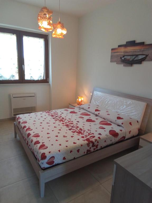 a bedroom with a bed with red flowers on it at Villa Anna Maria in Polignano a Mare