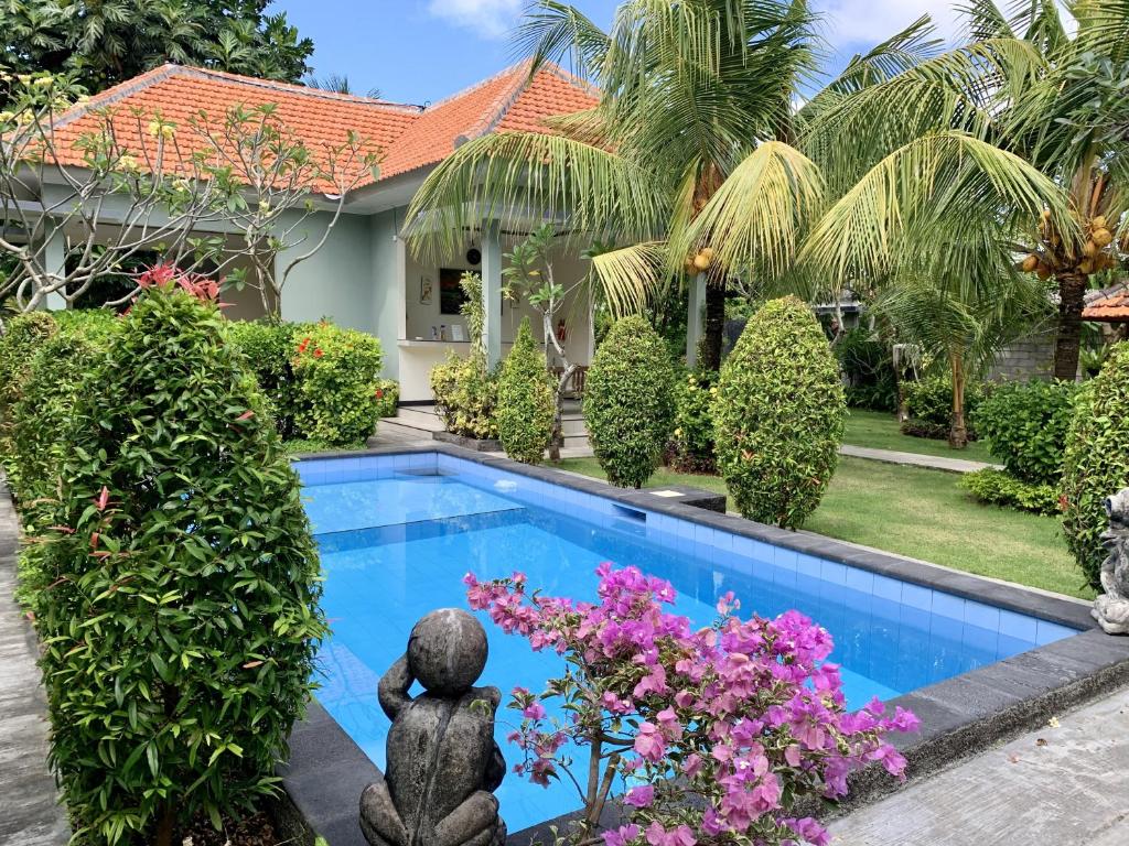 a villa with a swimming pool and a garden at Davit Guesthouse Nusa Dua in Nusa Dua