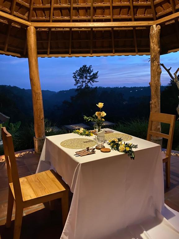a white table with flowers on it with a view at ECOZY by Biji Valley in Selat