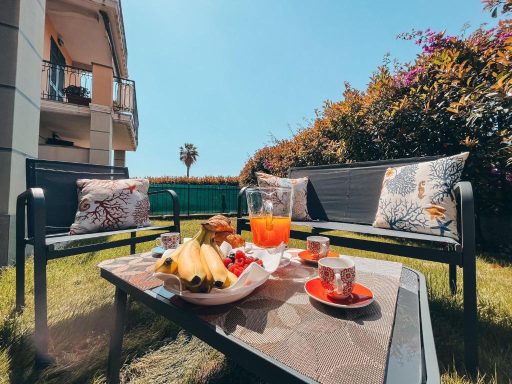 einen Tisch mit einer Schale Obst und einem Glas Orangensaft in der Unterkunft Appartamento Incantevole a 100metri dal mare e vicino a pista ciclabile in Imperia