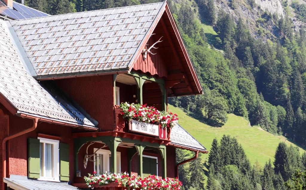 a building with flower boxes on the side of it at Café Pension zum Jäger in Buchboden