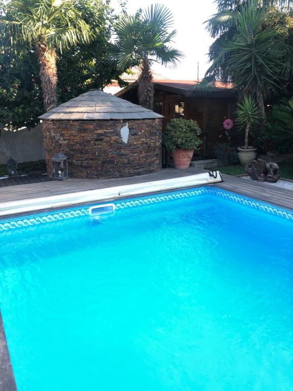 une grande piscine bleue en face d'une maison dans l'établissement Chalet - Piscine - Wifi, à Penta-di-Casinca