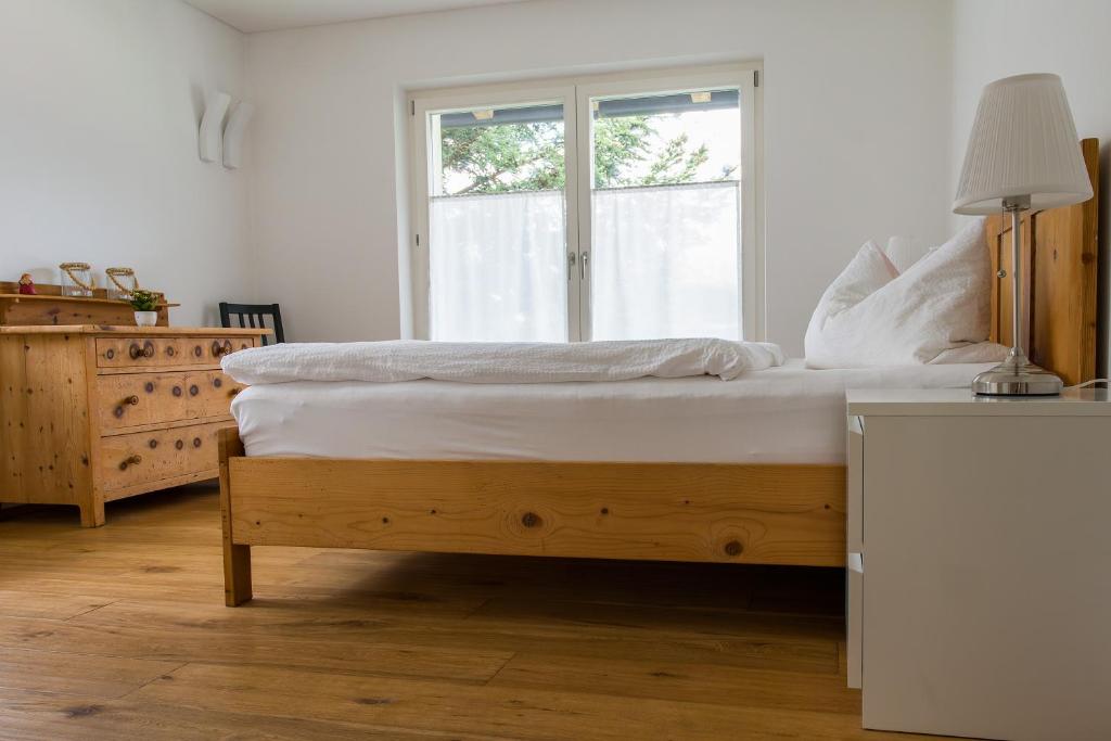 ein Schlafzimmer mit einem großen Bett und einem Fenster in der Unterkunft MANTANA - Apartments in St. Lorenzen