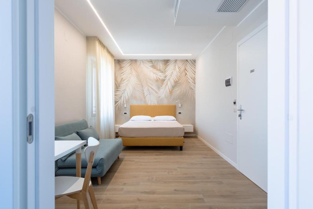 Habitación pequeña con cama y sofá en Albergo Degli Amici, en Chieti