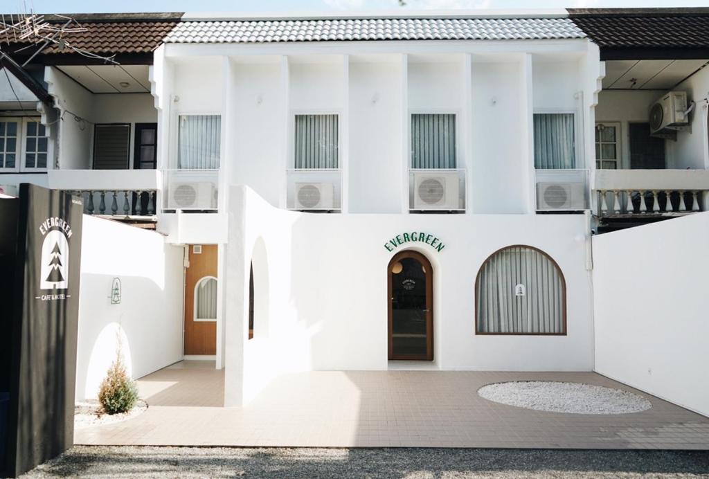 un bâtiment blanc avec une porte au milieu dans l'établissement Evergreen Cafe and Hotel, à Chiang Mai