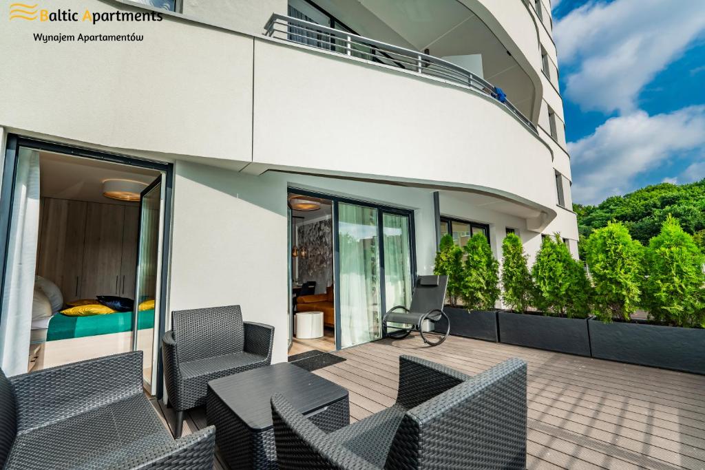balkon domu z krzesłami i łóżkiem w obiekcie Baltic Apartments - Sun Towers w Świnoujściu