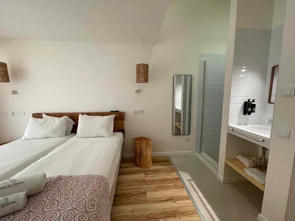 1 dormitorio con 1 cama y baño con lavamanos en Altinho B&B - Quartos - Rooms - Odeceixe, en Odeceixe