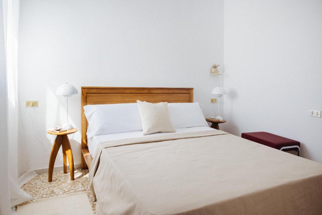 a bedroom with a large bed with white sheets at La Casa de La Caleta by Taller96 - El Hierro Island - in La Caleta