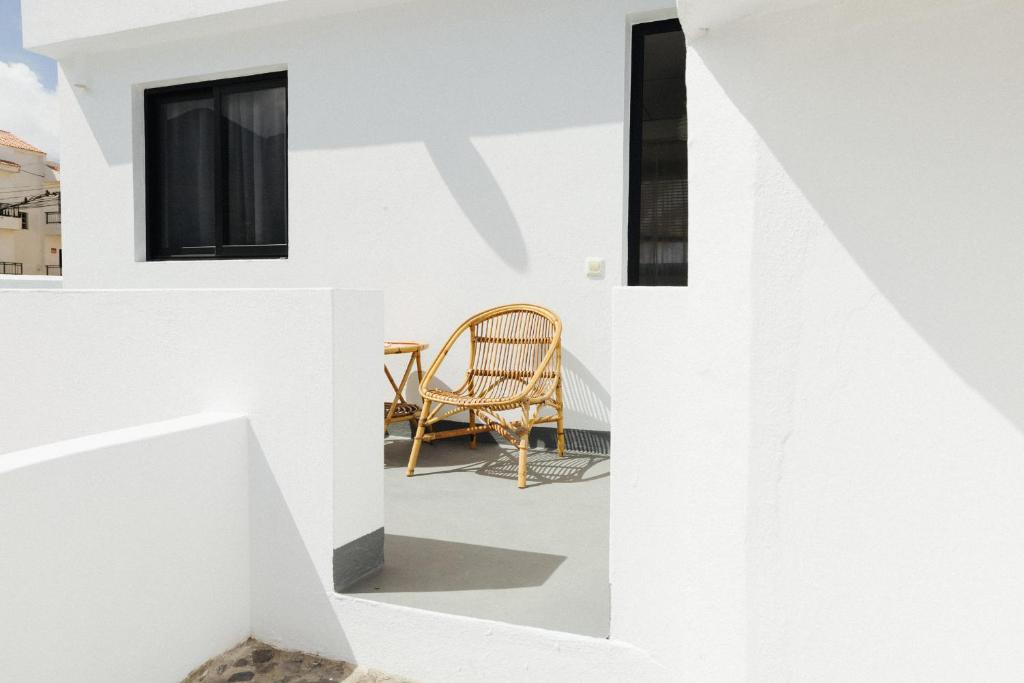 a room with white walls and a wooden chair at La Casa de La Caleta by Taller96 - El Hierro Island - in La Caleta
