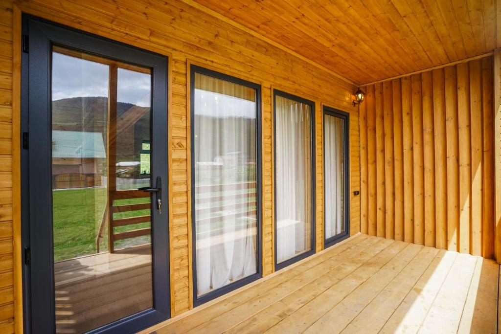 a porch of a house with sliding glass doors at wood house in Mestia