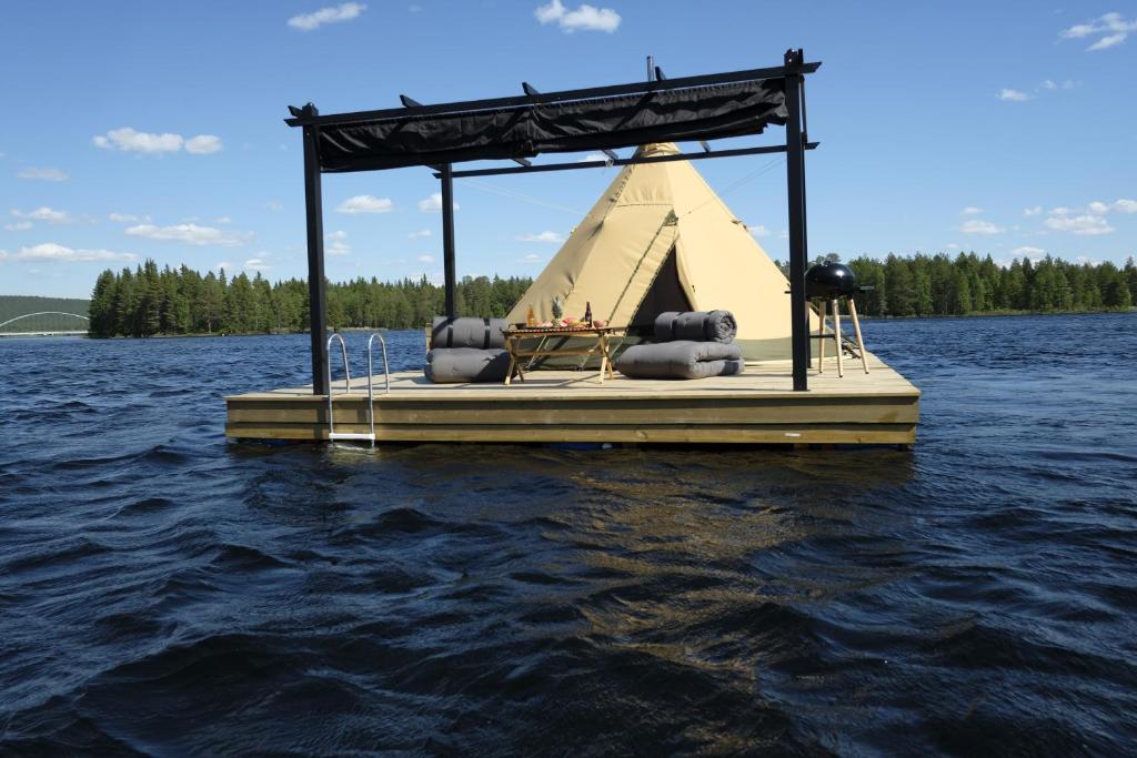 a dock on a lake with a pavilion on the water at Tentipi River Camp in Sorsele