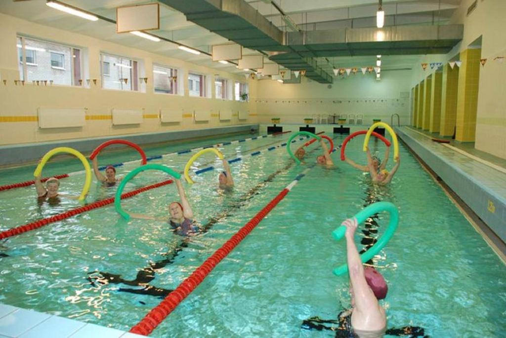 a group of people swimming in a swimming pool at Tamsalu Spordikompleksi Hostel in Tamsalu