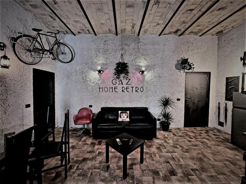 un soggiorno con divano e una bicicletta appesa al muro di GAZ HOME RETRÒ Apartment a Roma